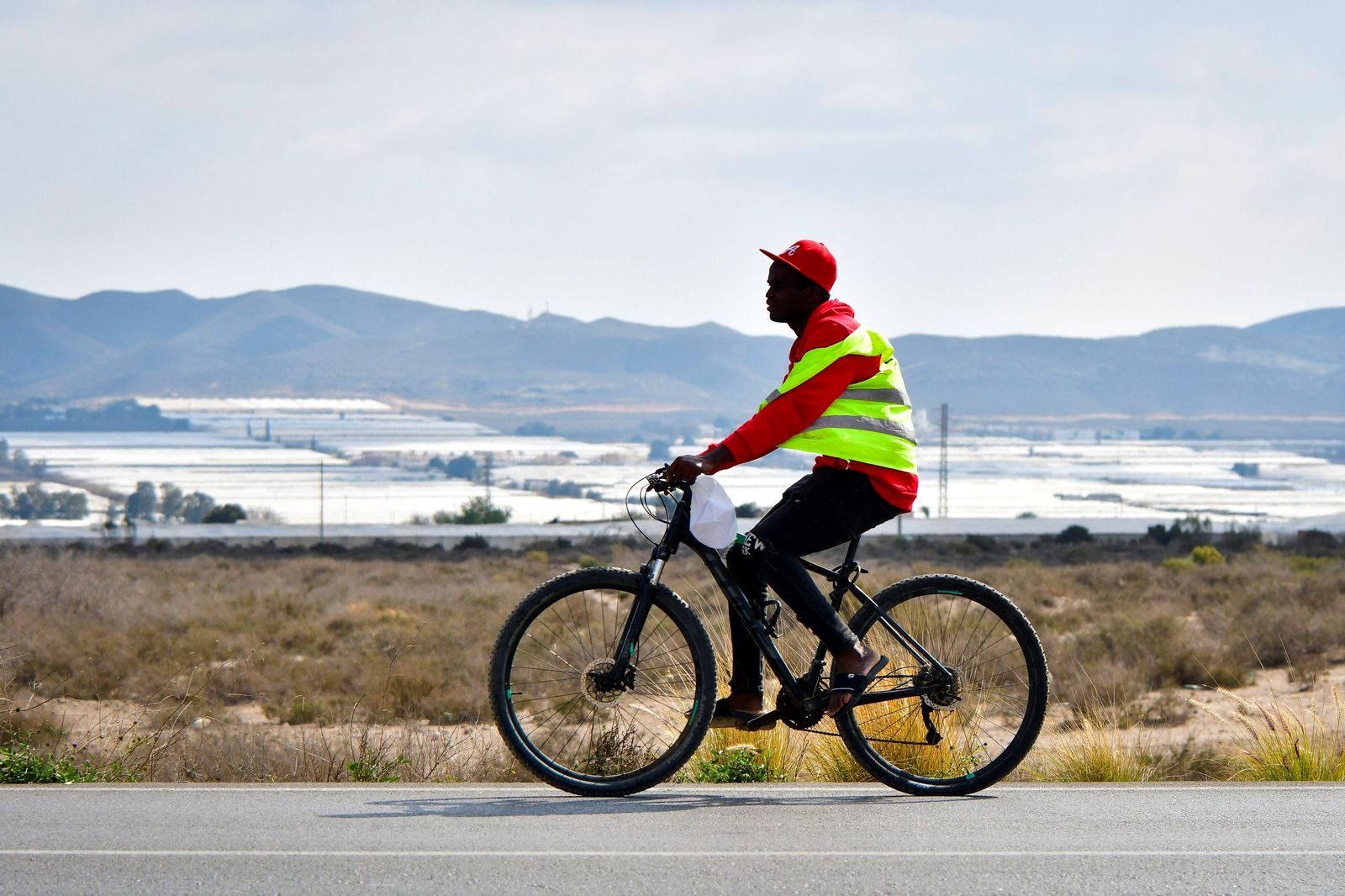 Un migrante se desplaza en bicicleta en el municipio de Níjar.