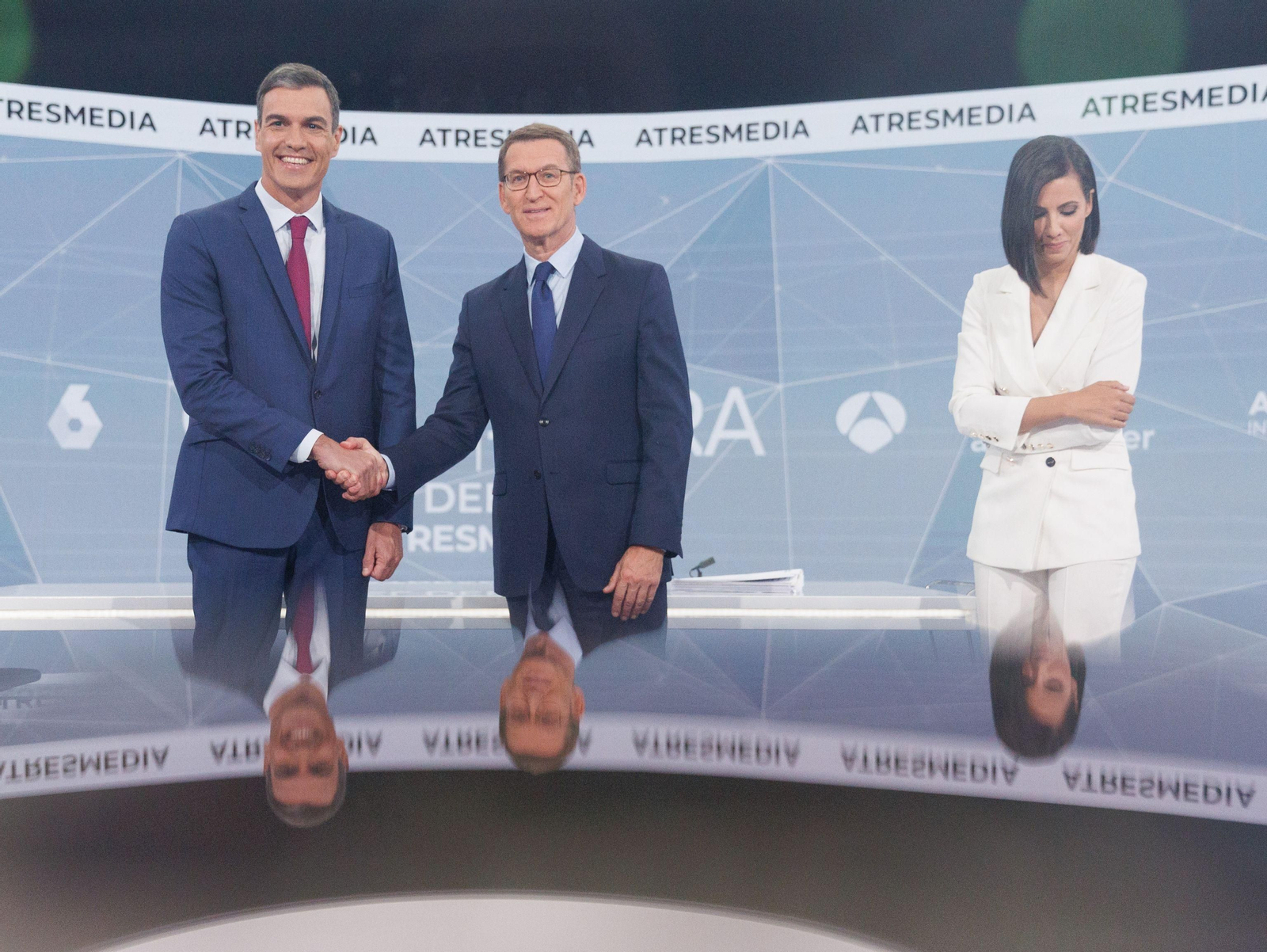 Pedro Sánchez y Núñez Feijóo se dan la mano antes del cara a cara. A la derecha, Ana Pastor