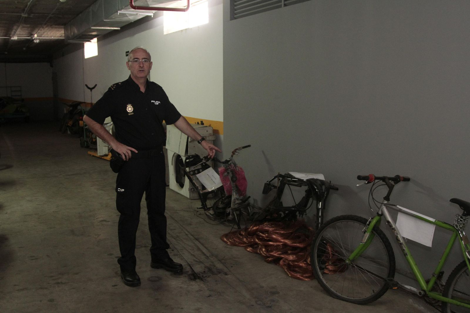 El inspector José María Belloso muestra dos chasis de motos recuperadas, en el garaje de la comisaría de Sevilla Este.