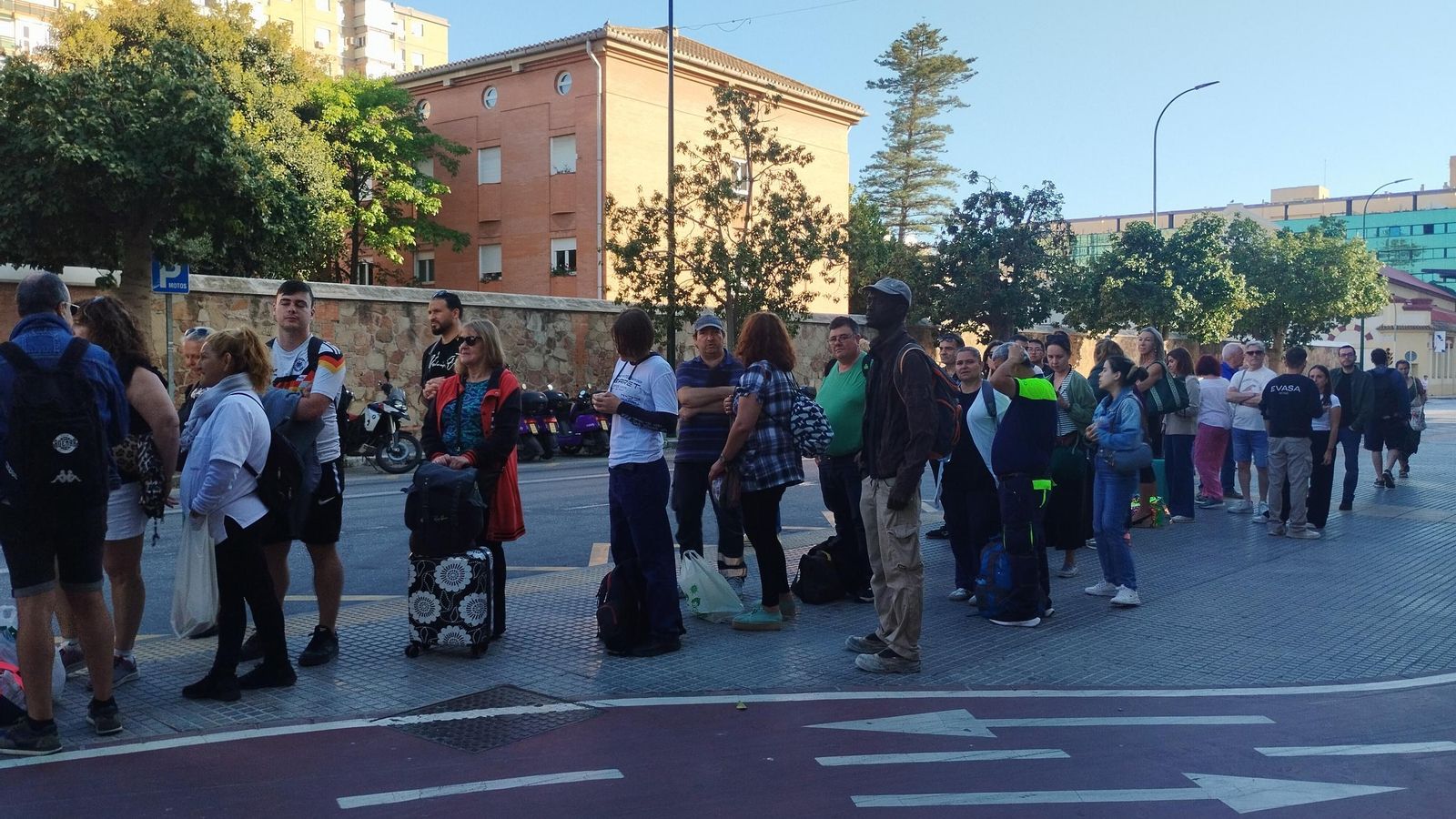Aglomeración de personas junto a la estación de trenes esperando autobuses hacia la costa.