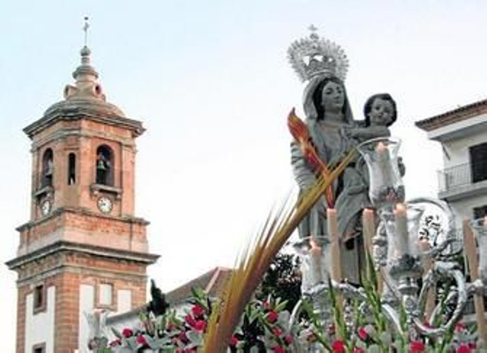 La Virgen de la Palma en su salida del templo con la iglesia en el fondo de la imagen, ayer por la tarde.