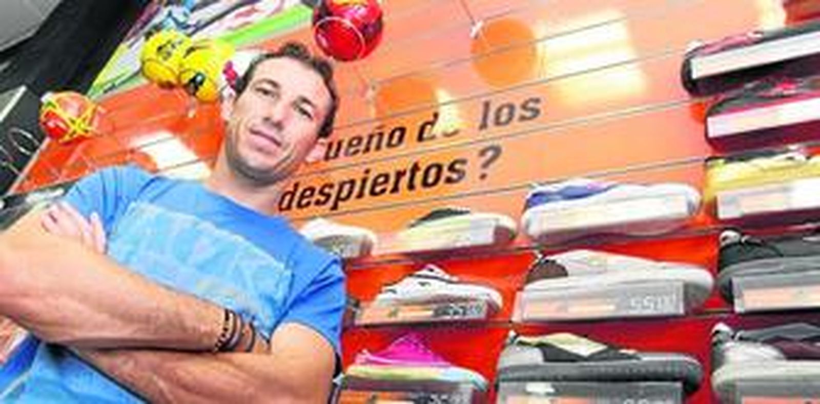 Josemi posa delante del estante de calzado deportivo, en el interior de su tienda Josemi Sports.