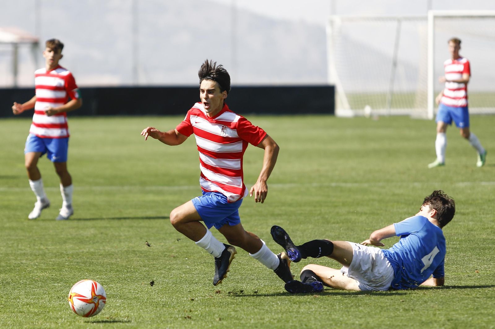 Un futbolista del filial escapa de la entrada de un rival.