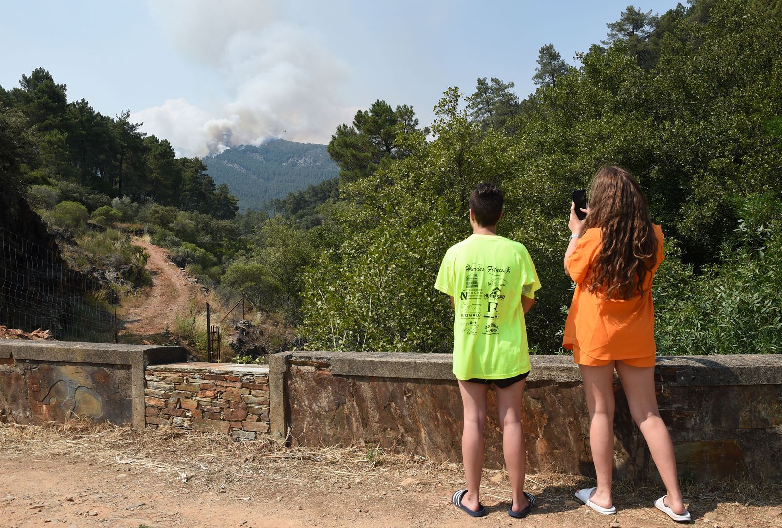 Dos personas observan el incendio de la comarca de Las Hurdes, en Cáceres.