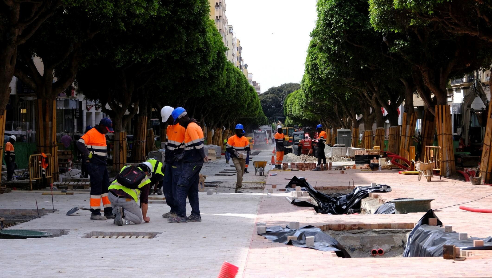Trabajadores ajustan el adoquinado bicolor.