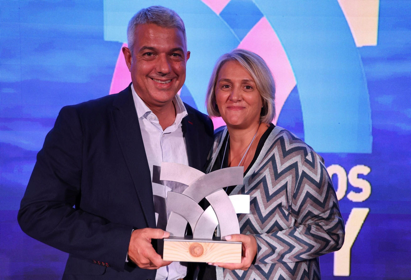 Toni de la Prieta y Nuria Iglesias posan posando con el galardón otorgado a Accenture.
