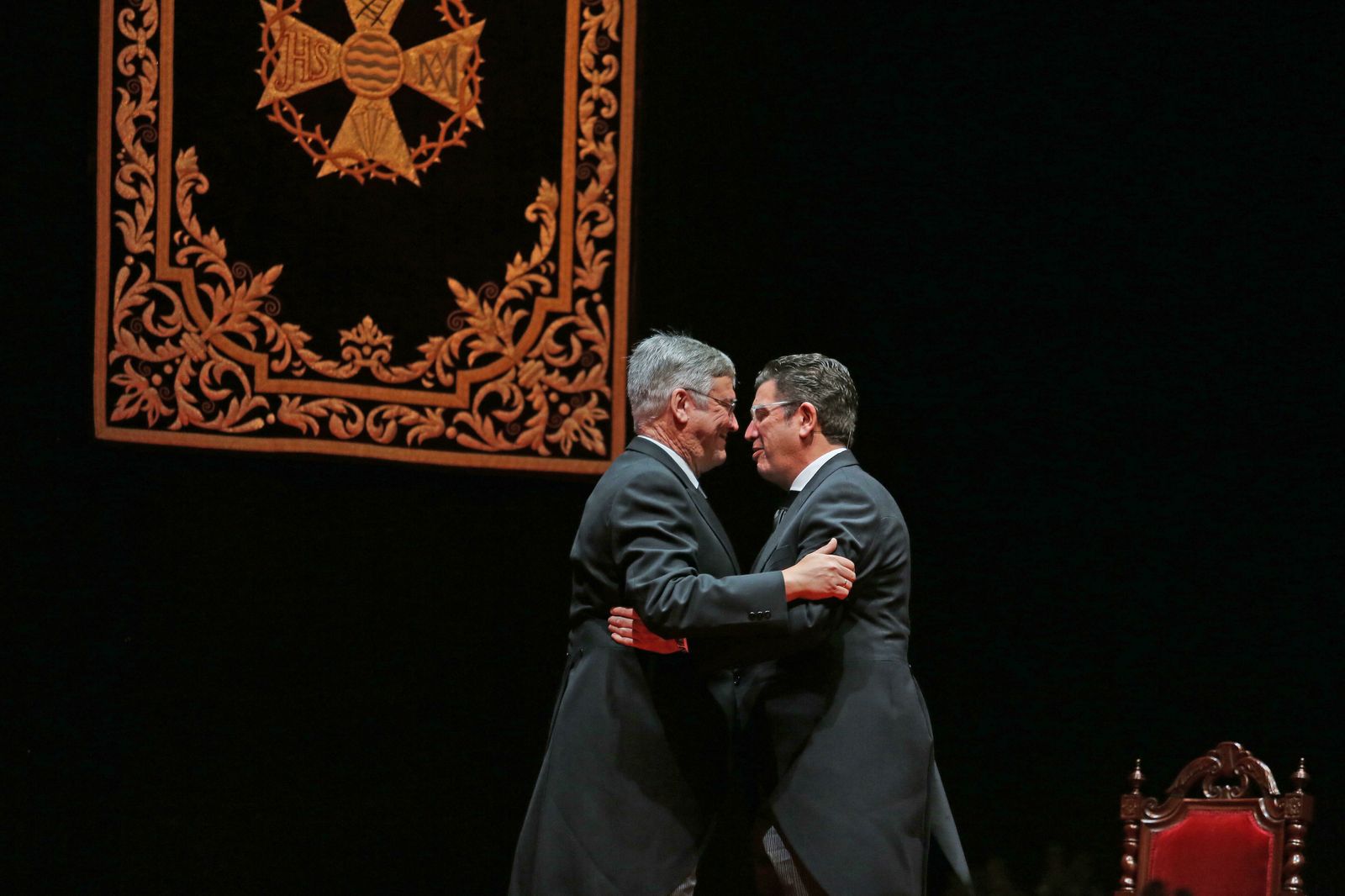 Antonio Moure abraza a su presentador en el Teatro Villamarta el su pregón de la Semana Santa de 2015.