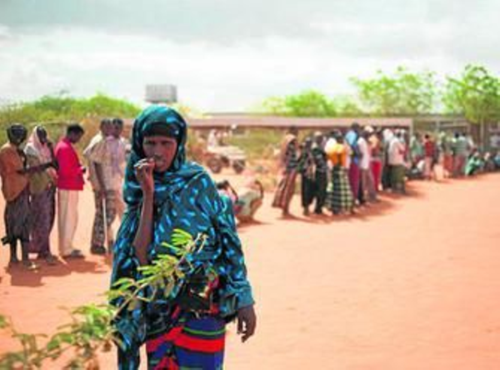 Una mujer somalí delante de una cola para llegar a la recepción del campamento de refugiados de Kenia.
