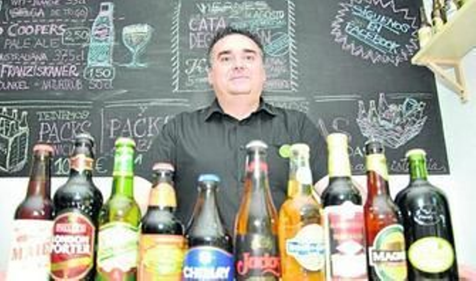 Mario Fernández posa en su establecimiento con una selección de cervezas.