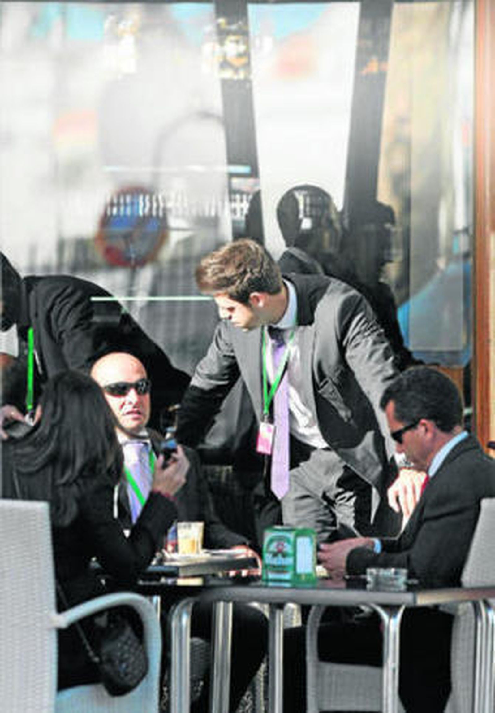 Personal con acreditación de la Cumbre, tomándose un descanso en una terraza de la ciudad.