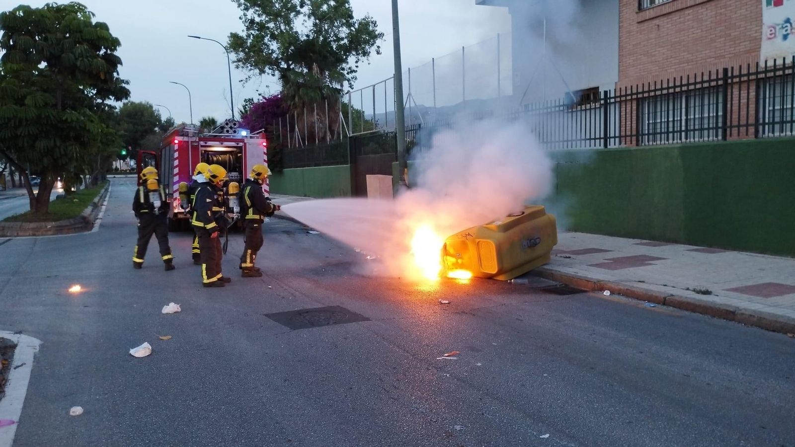 Bomberos sofocando el fuego que provocaron supuestamente los ultras en un contenedor.