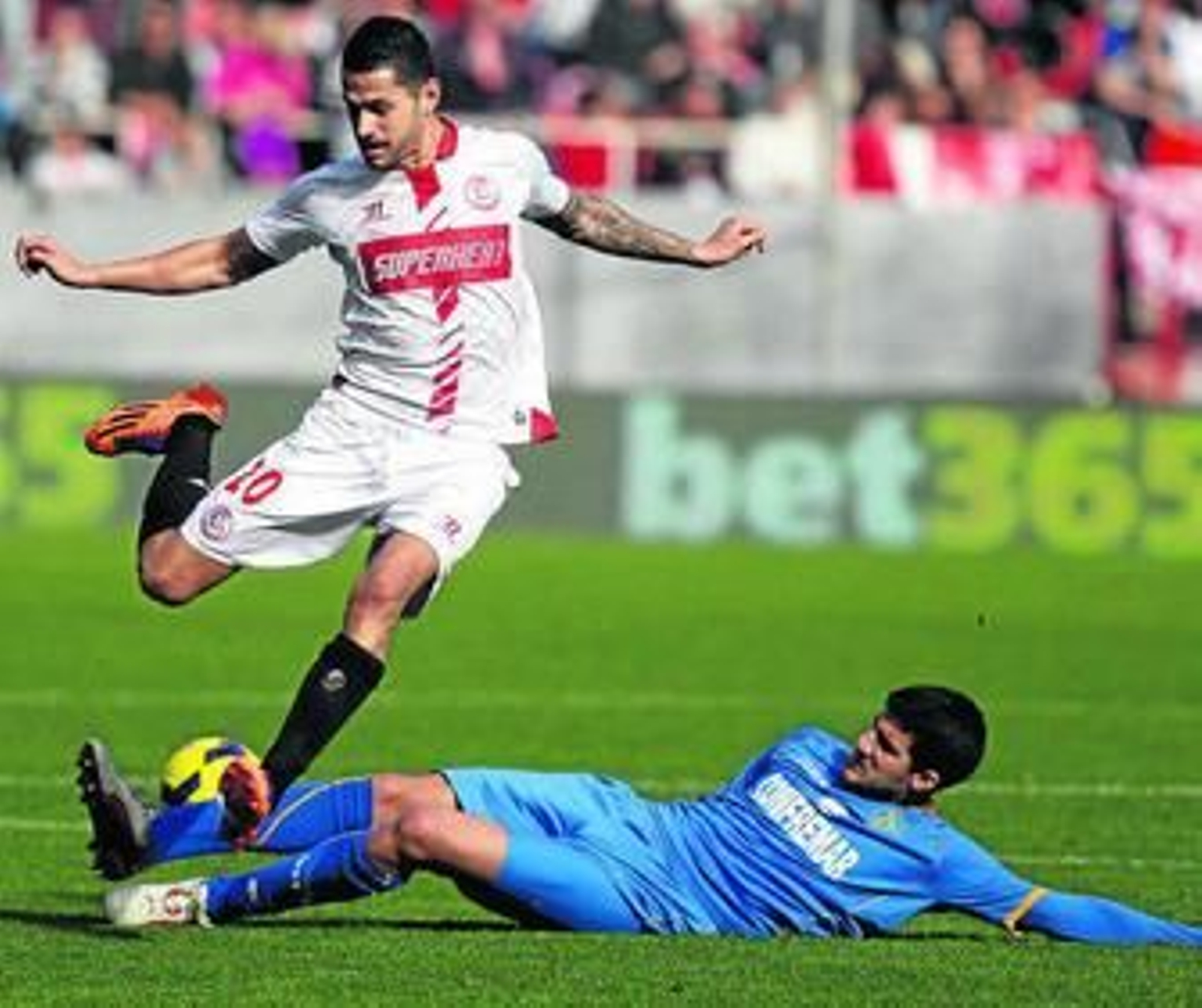 Vitolo trata de esquivar la entrada de Lisandro López durante el encuentro.