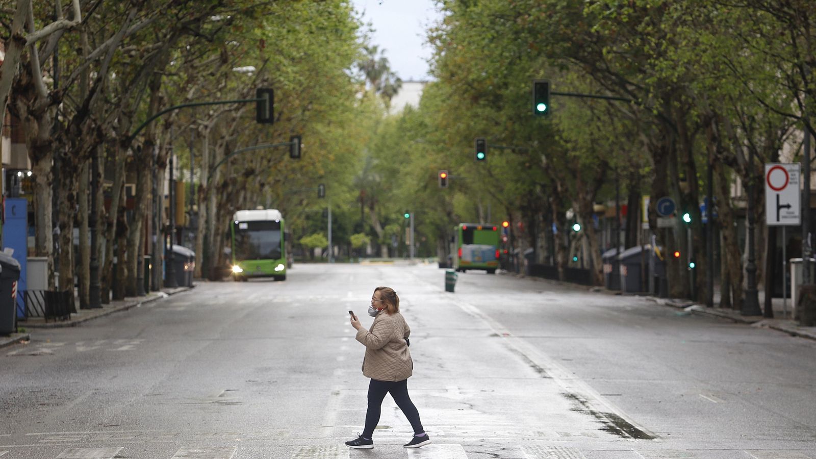 Una mujer cruza un semáforo de ronda de los Tejares.