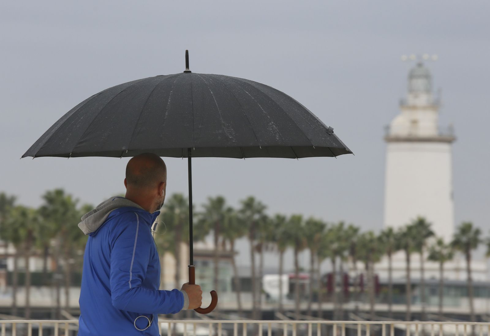 Un hombre se protege de la lluvia con un paraguas.