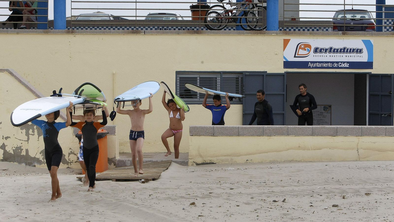 Unos pequeños con sus tablas en una actividad de la escuela de surf.