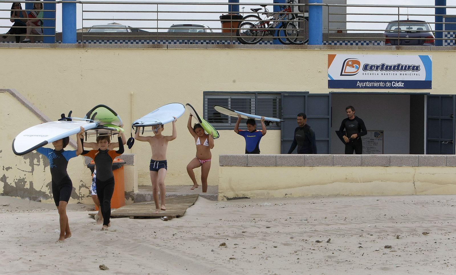 Unos pequeños con sus tablas en una actividad de la escuela de surf.