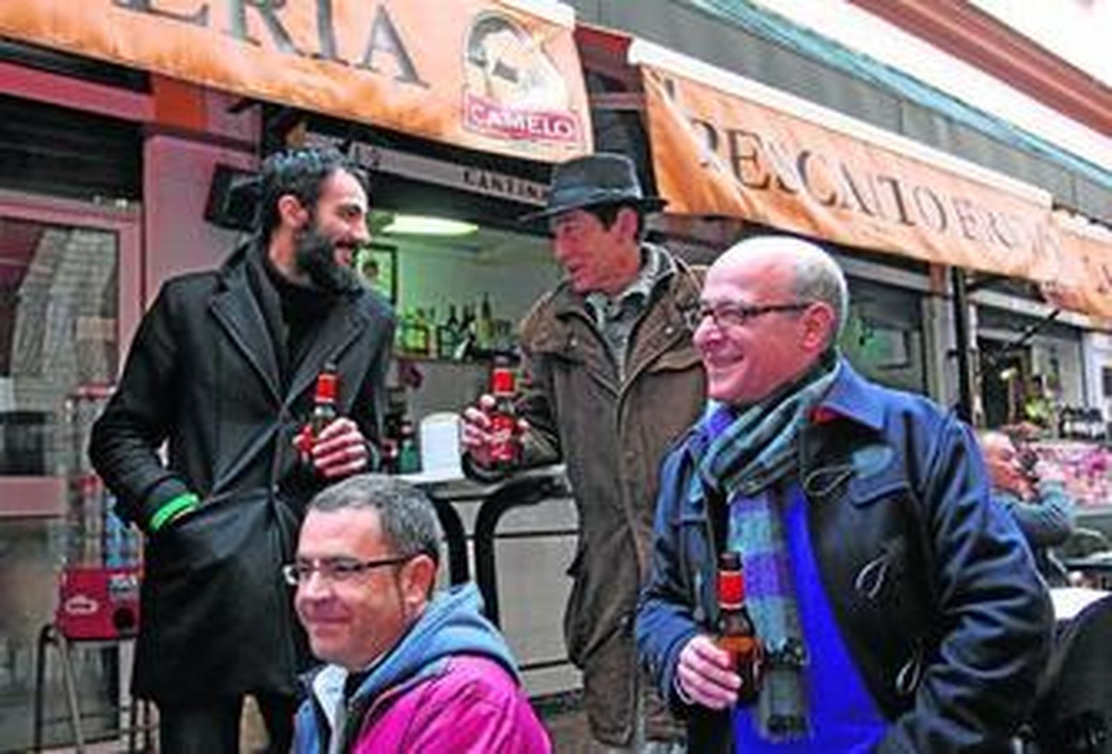 Mora y Mansilla, detrás de Navarro (sentado) y de Manuel Llanes, ayer en el mercado de la calle Feria.