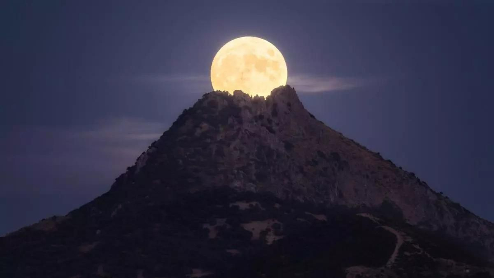 Una imagen de la luna sobre un cerro