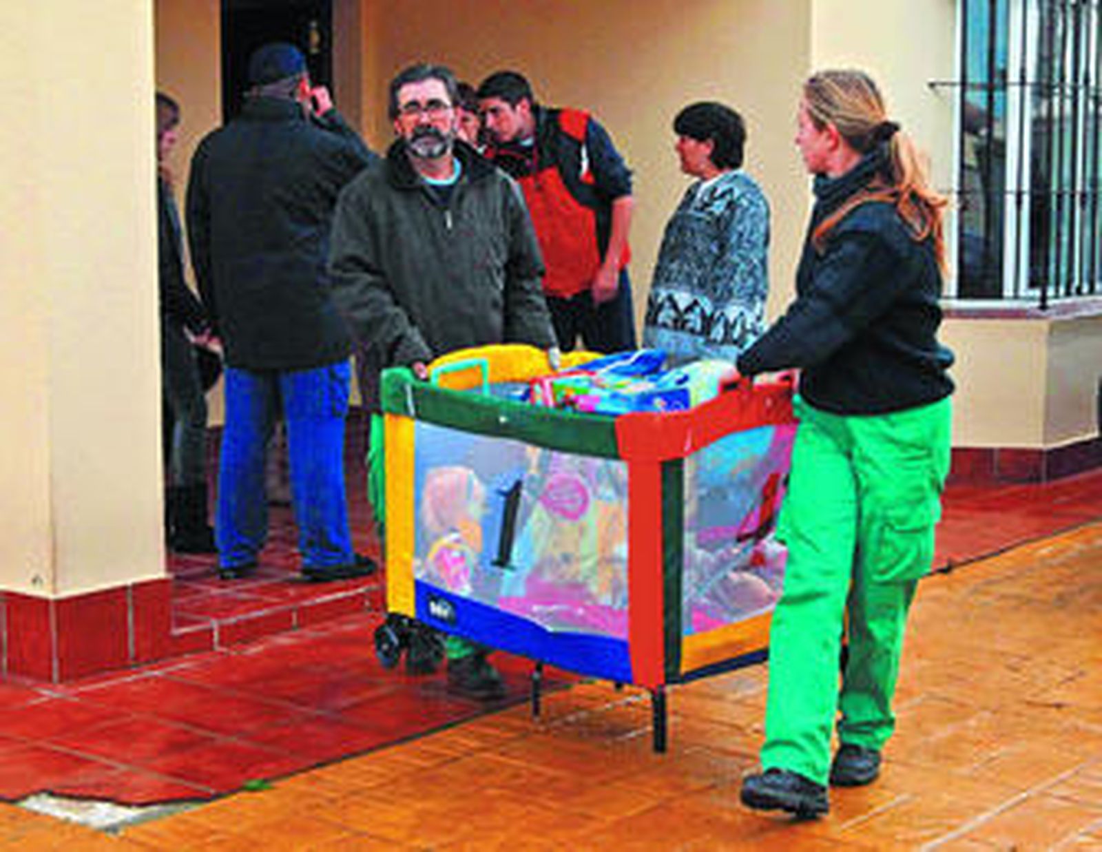 Vecinos frente a las edificaciones que se quieren tirar y junto a una docena de vehículos patrullas de la Policía Local.
