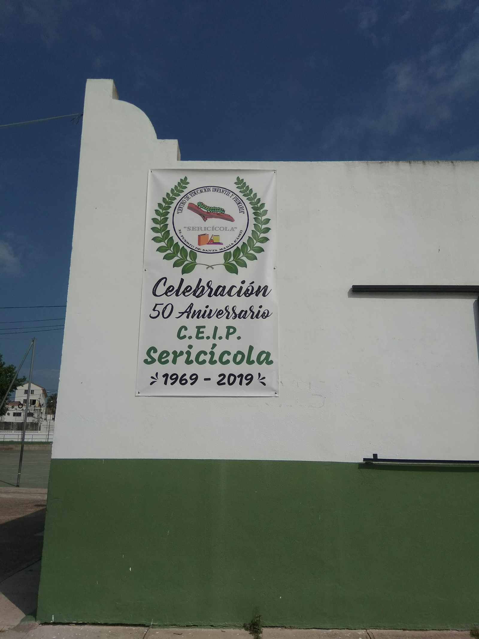 Un cartel en la fachada del colegio Sericícola, conmemorativo de su 50 aniversario.