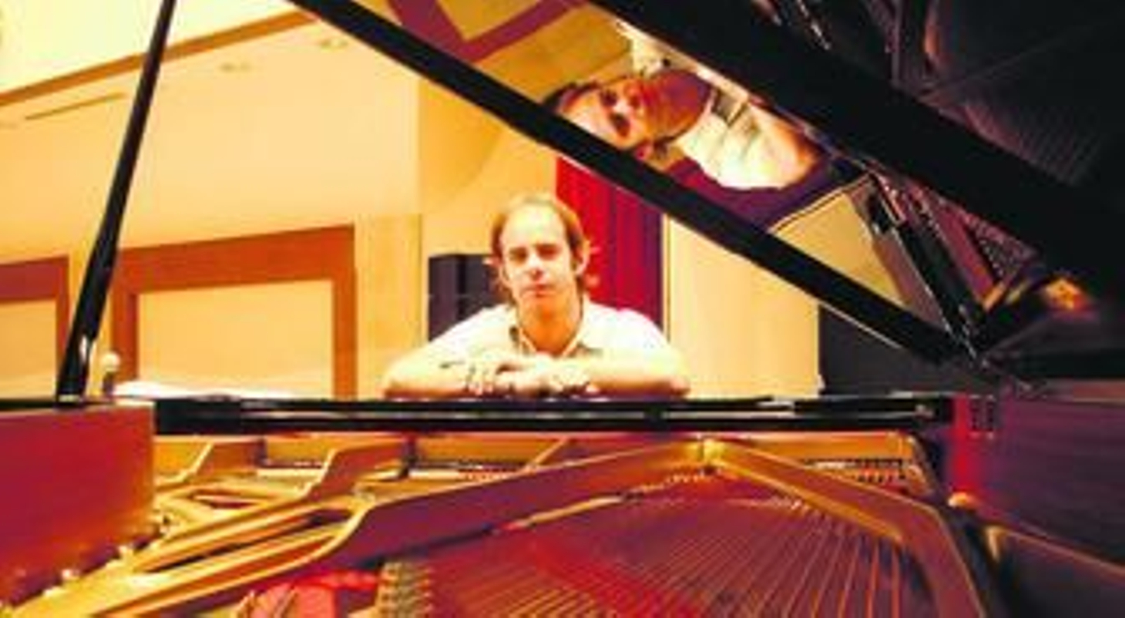 Imagen del músico de jazz afincado en San Roque, Juan Gómez Galiardo, junto al instrumento que mejor domina, el piano.