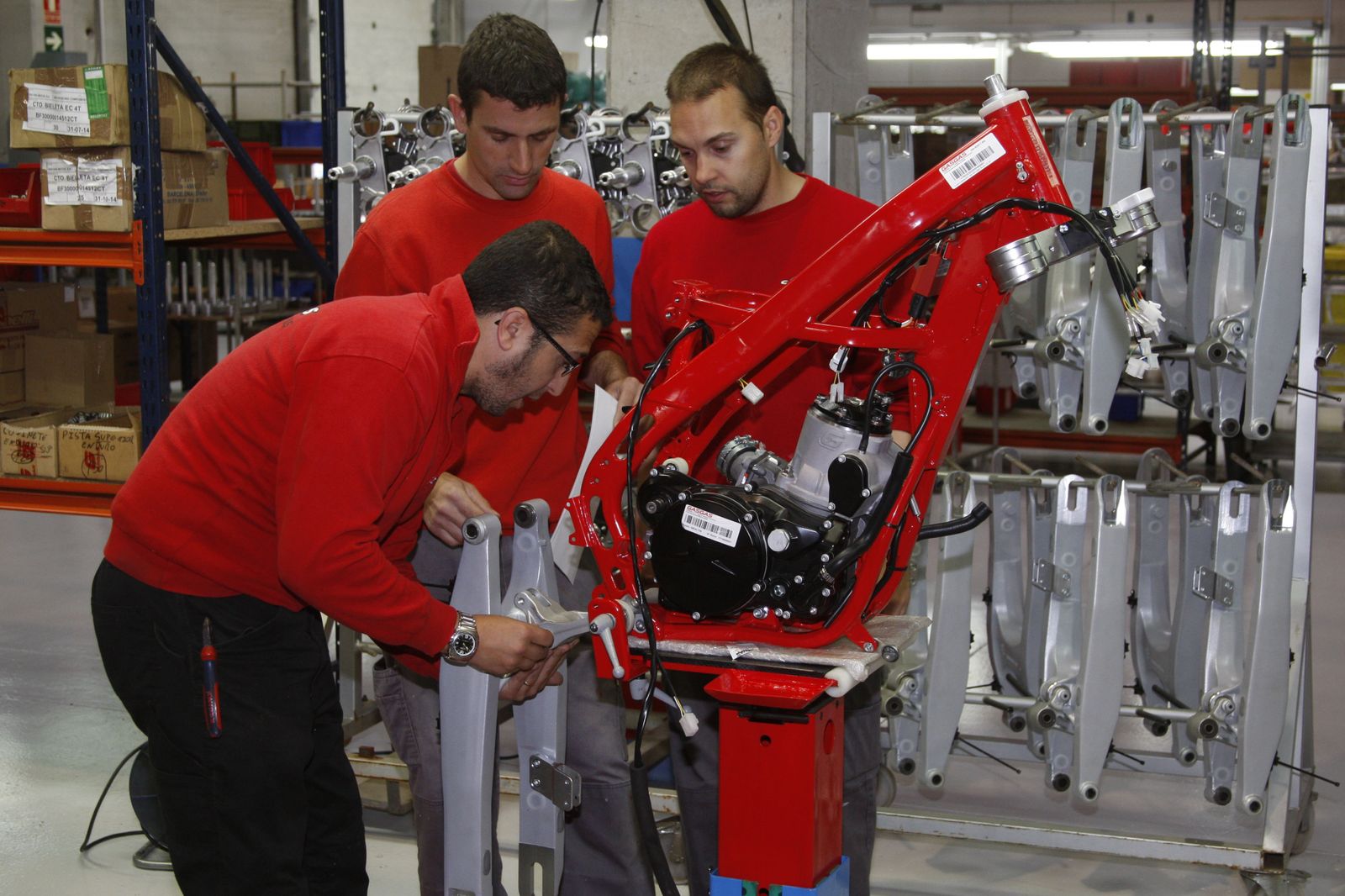 Tres operarios de la fábrica de Torrot en Girona, durante la construcción de una de los motocicletas.