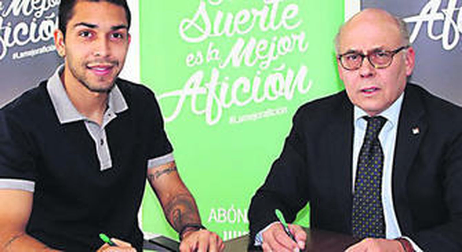 Petros y Juan Carlos Ollero escenifican la firma del contrato.