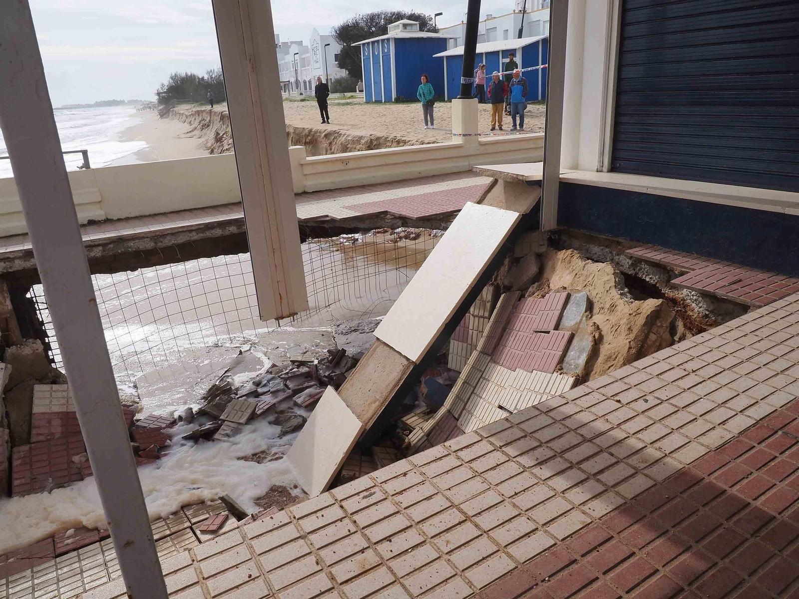 Varios vecinos observan las dimensiones del socavón