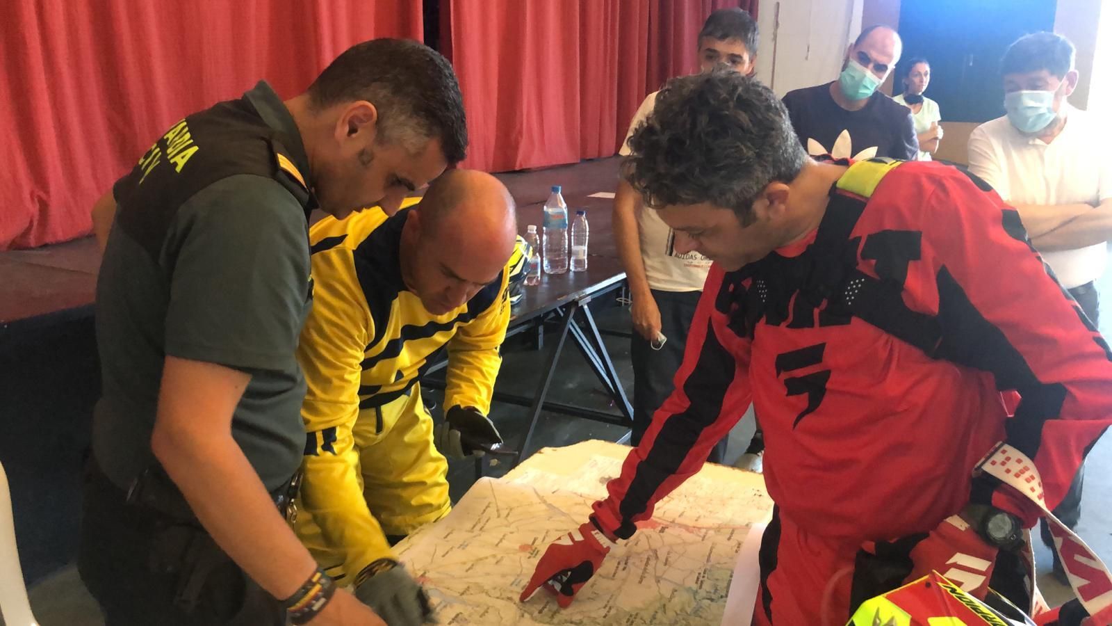 Un agente da instrucciones a dos aficionados al motocross, voluntarios en la búsqueda.