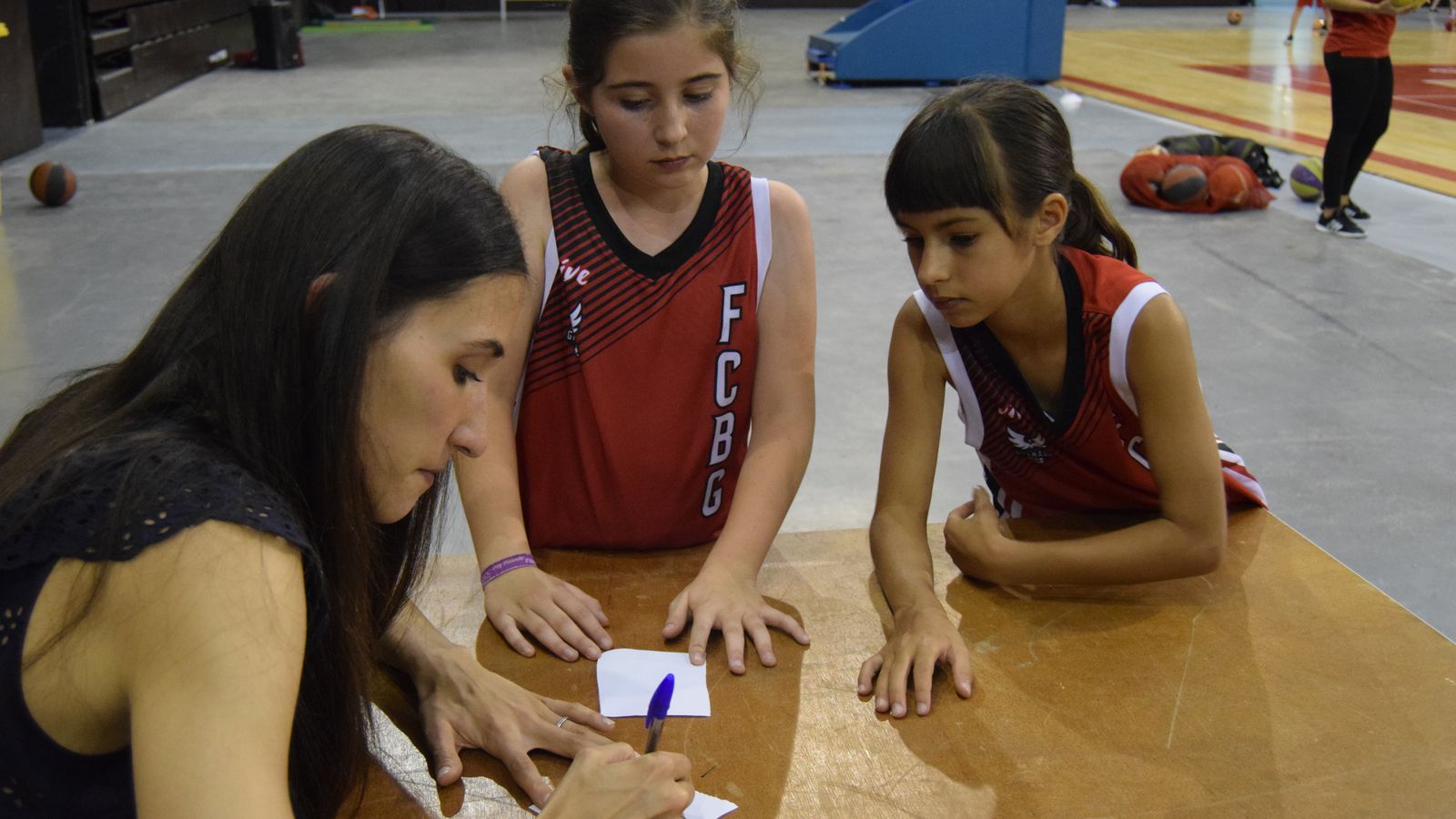 Belén Arrojo firma un autógrafo a dos niñas del Fénix Camp