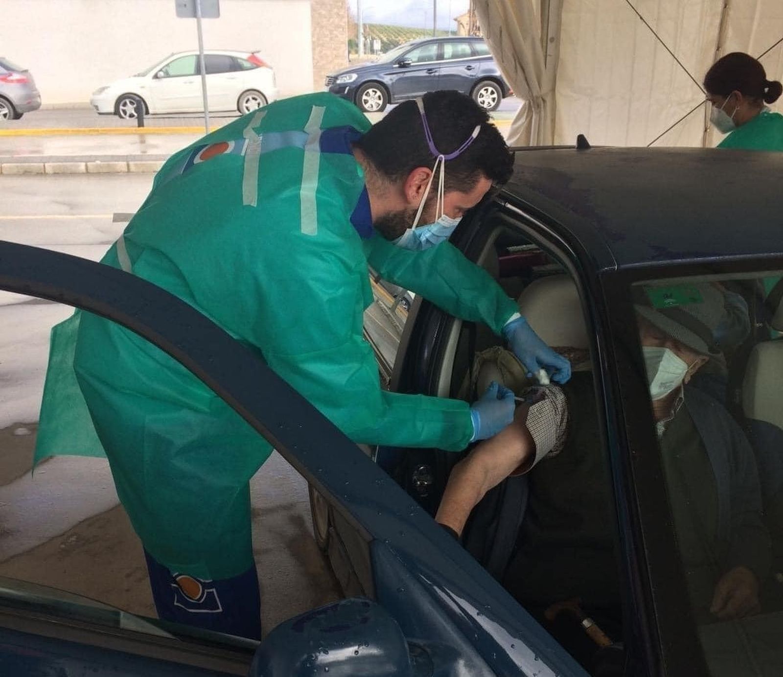 Un sanitario vacuna a una persona mayor.