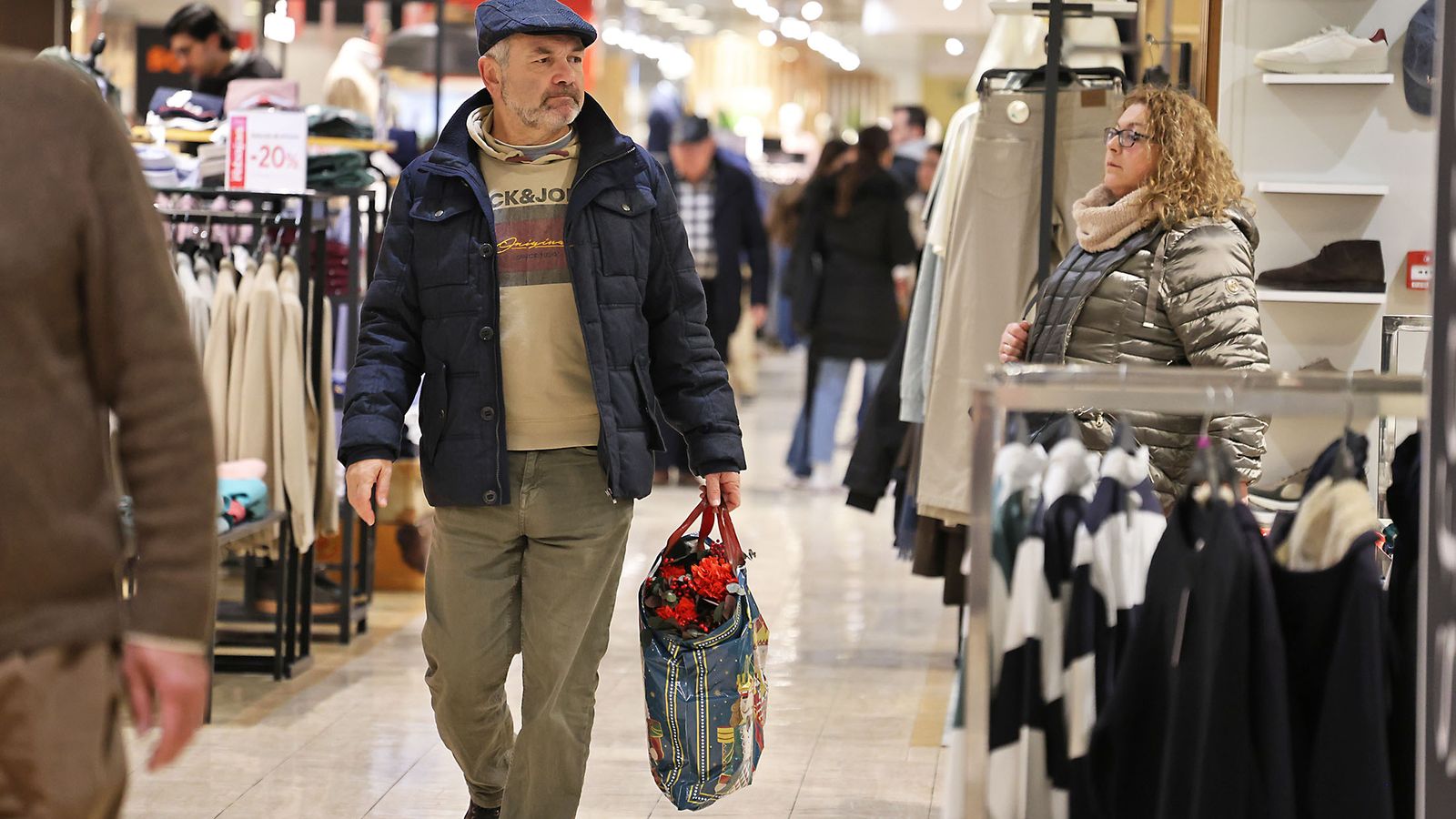 Un señor con su bolsa saliendo del centro comercial Costa Luz Huelva.