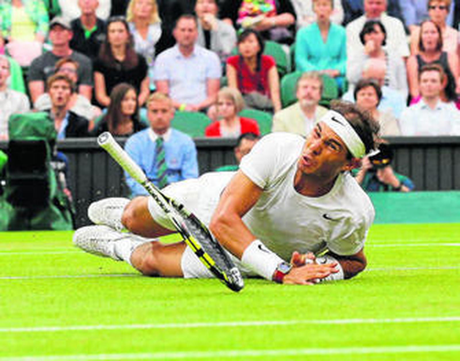 Nadal, en el suelo tras lanzarse a la hierba de la pista central de Wimbledon para devolver una bola a Kukushkin.