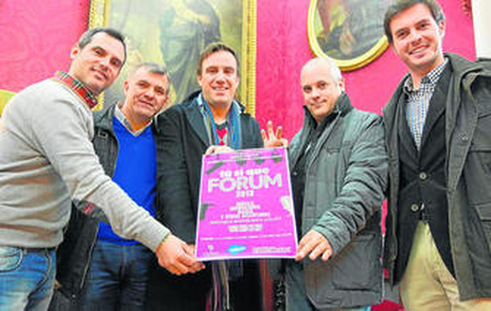 Los organizadores, con el cartel que recoge los detalles del evento.