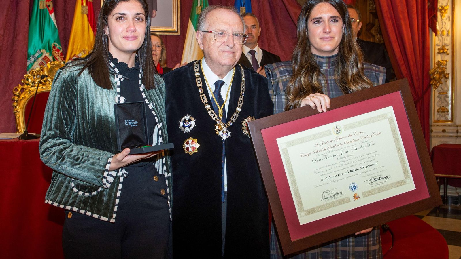 María y Aída, hijas de Francisco Javier Sánchez Rea, ex secretario general del Colegio, reciben el título de la Medalla de Oro al Mérito Profesional otorgado a su padre.