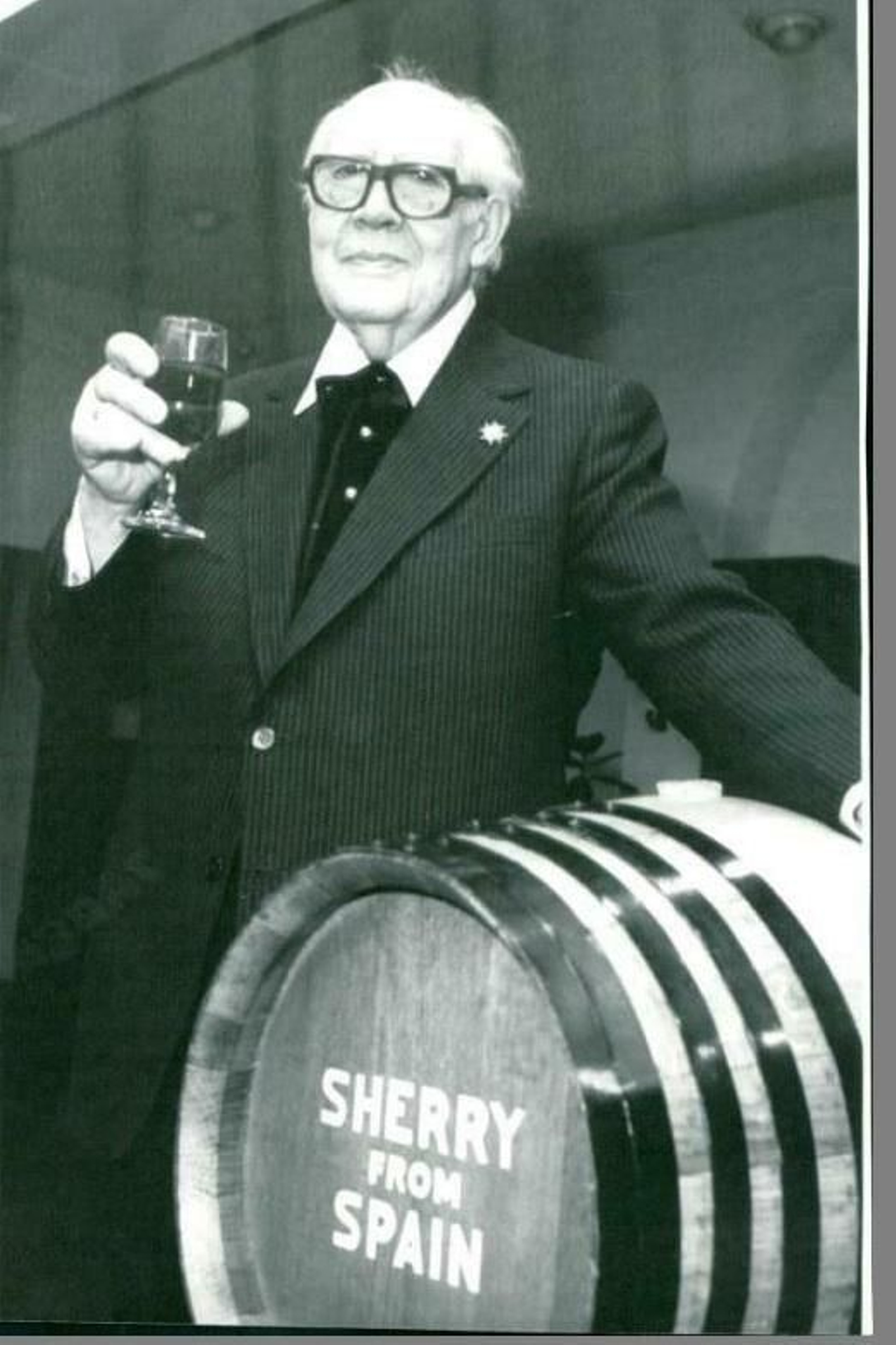 El músico Andrés Segovia catavino en mano junto a un barril de jerez.