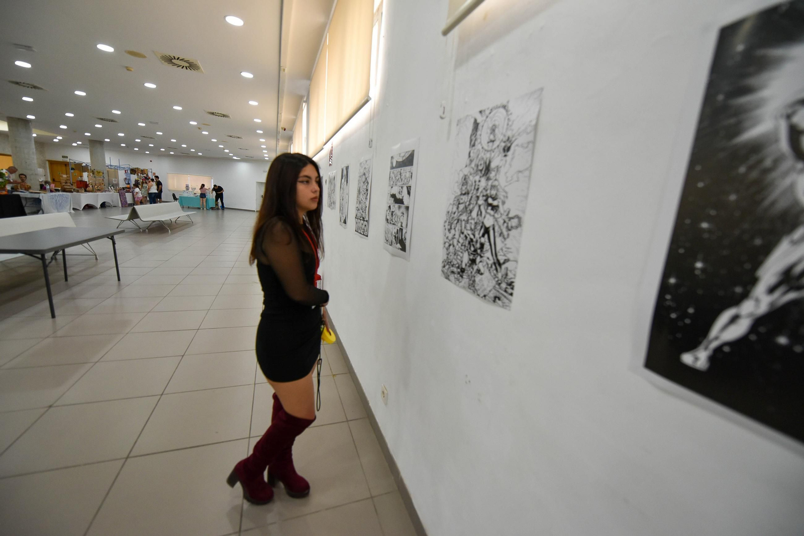 Una joven observa una exposición de comic en el Palacio de Congresos.