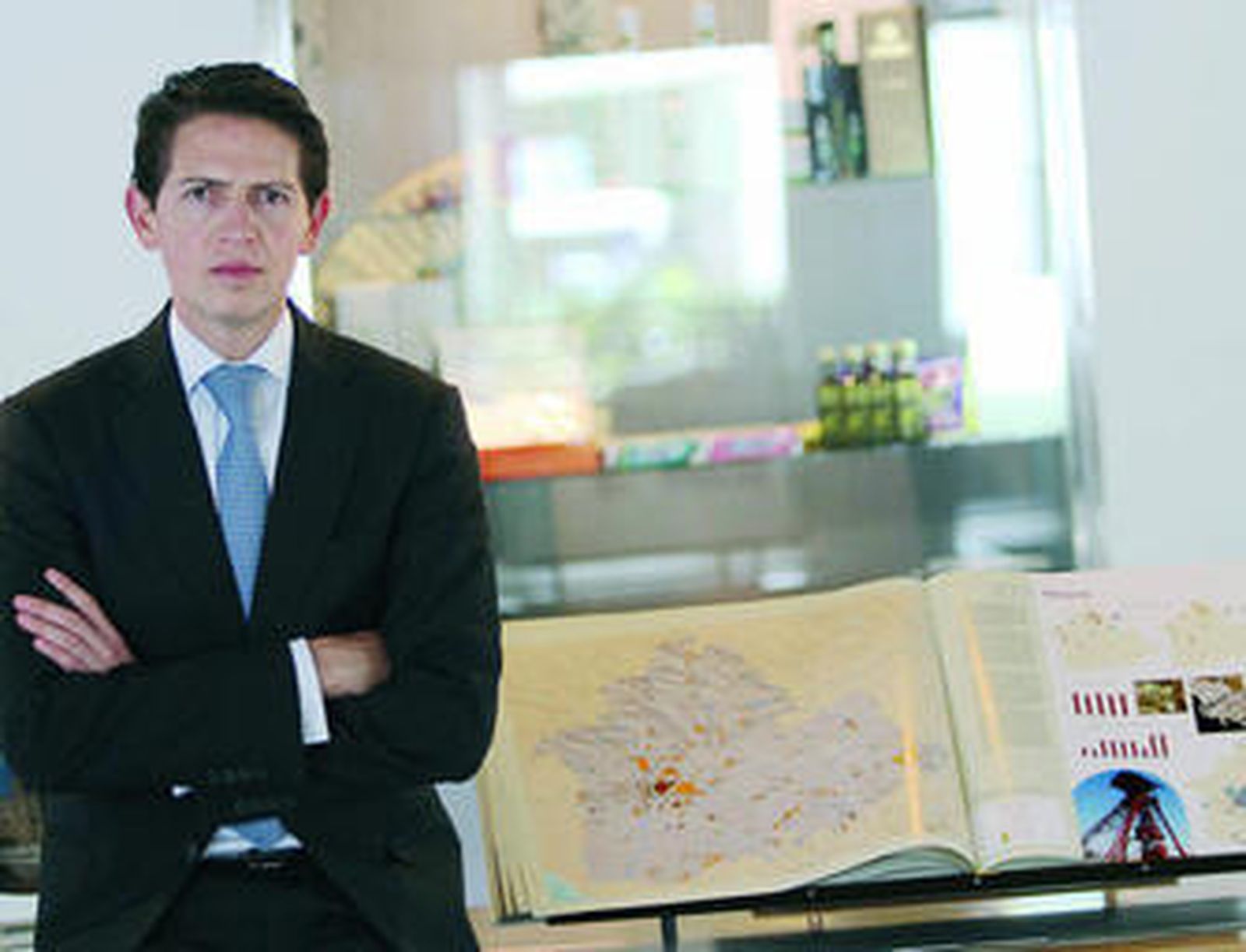 Muñiz, junto a un atlas de la provincia expuesto en el hotel Barceló Renacimiento y abierto por las páginas de minería.