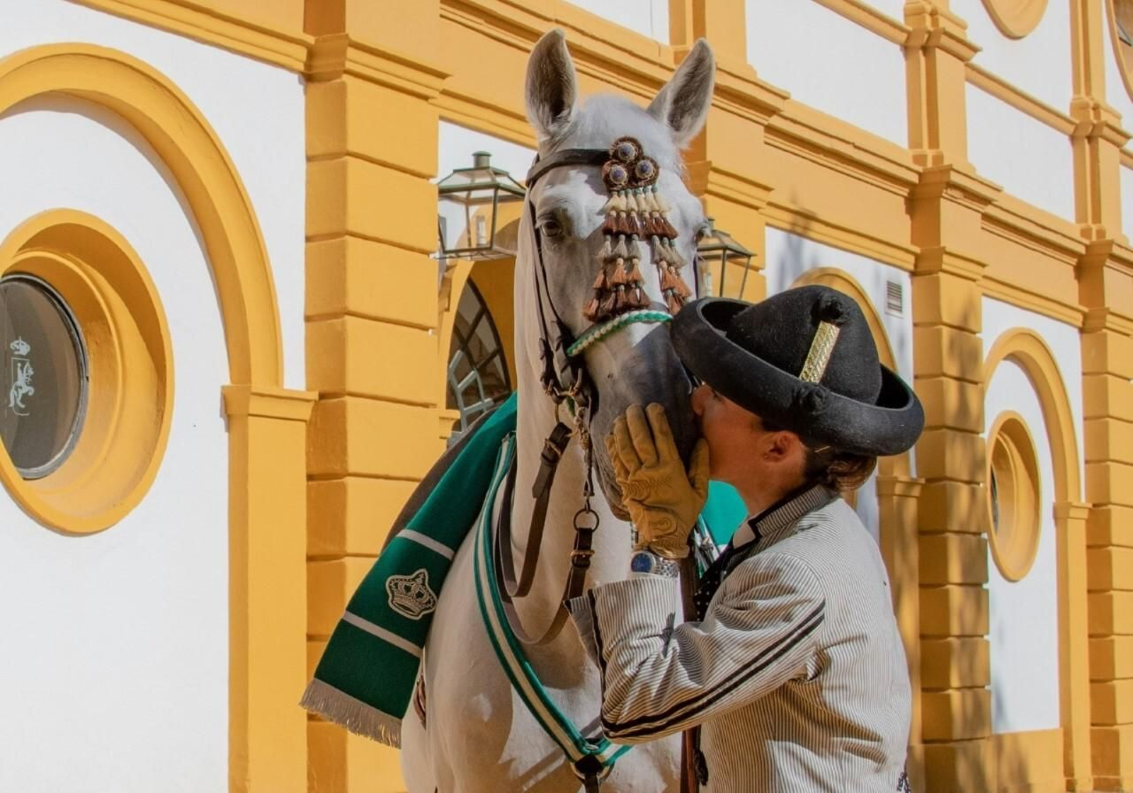 Una amazona de la Real  Escuela mimando a su caballo.