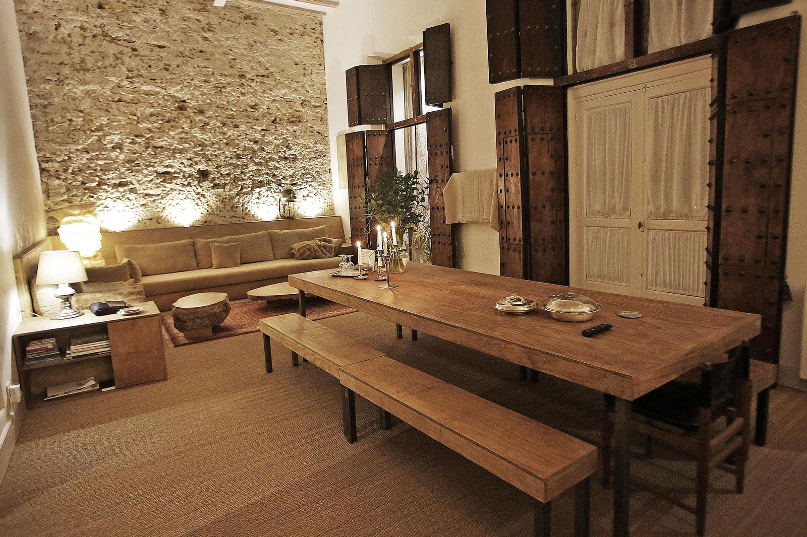 Imagen del salón con la amplia mesa de comedor y el sofá al fondo.