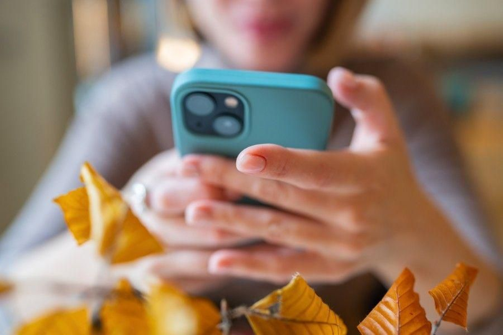 Una mujer mira su teléfono móvil.