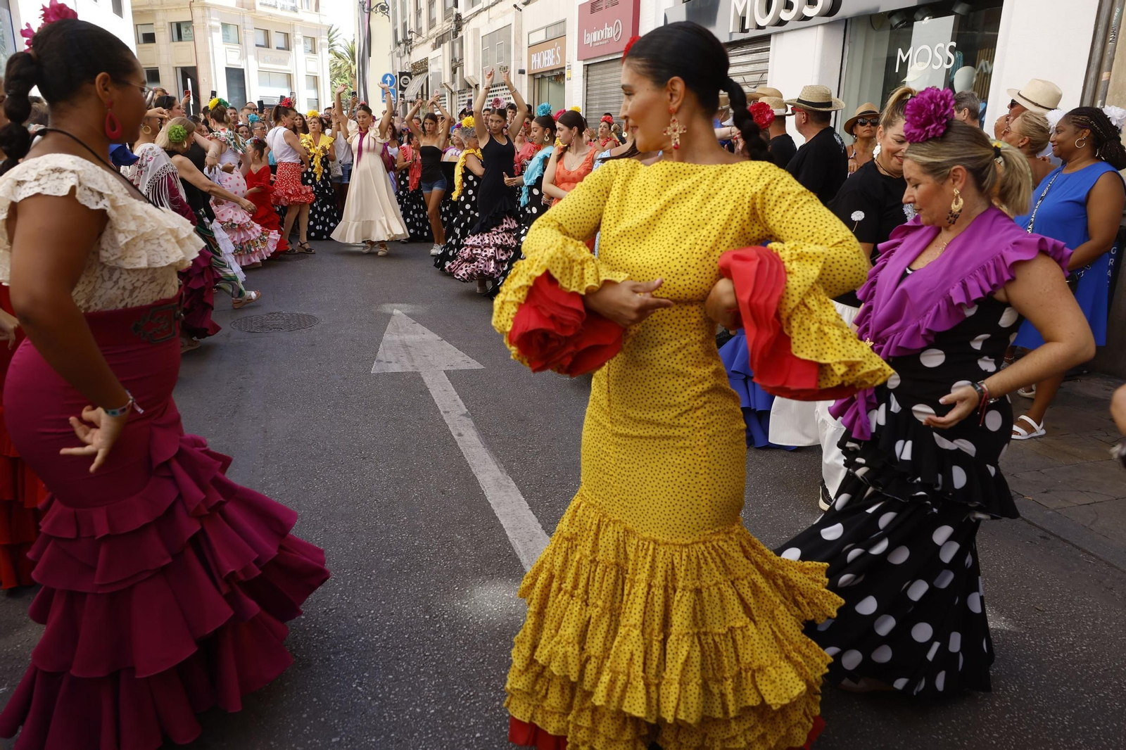 Un grupo de mujeres bailando con sus trajes de flamenca.