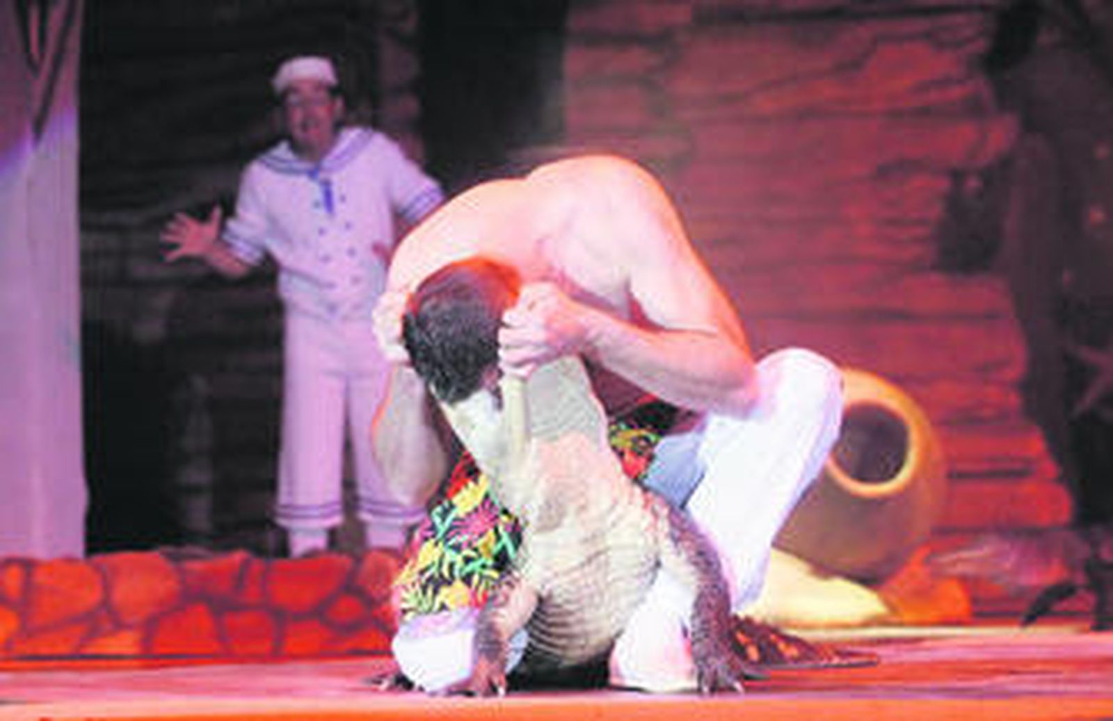 Un artista juega con uno de los cocodrilos ante la mirada del payaso, ayer.