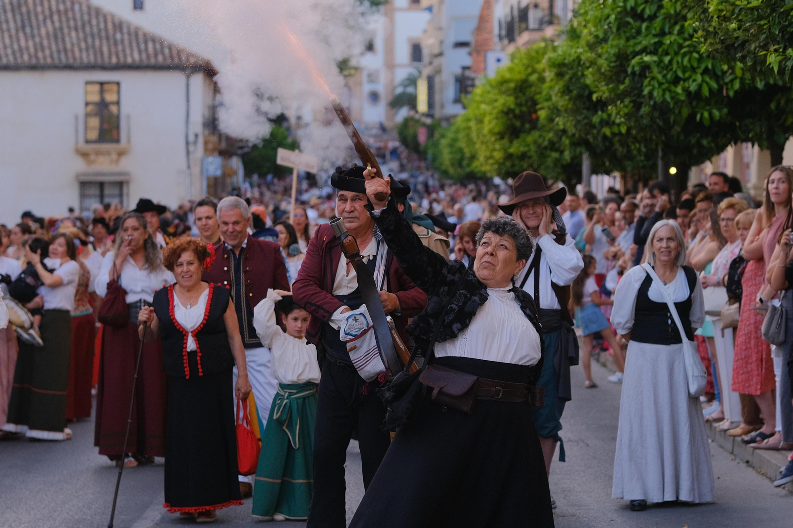 Una de las mujeres bandoleras realizando un disparo durante el pasacalles. Una de las mujeres bandoleras realizando un disparo durante el pasacalles.