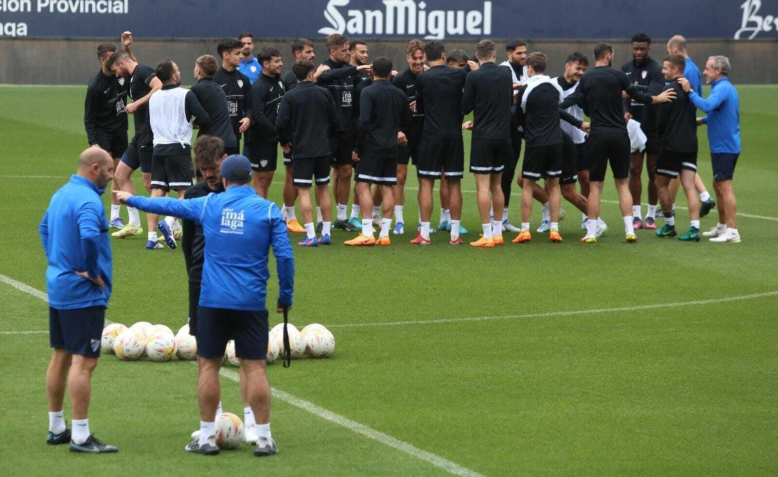 Guede conversa con Jozabed durante un entrenamiento, con el grupo al fondo.