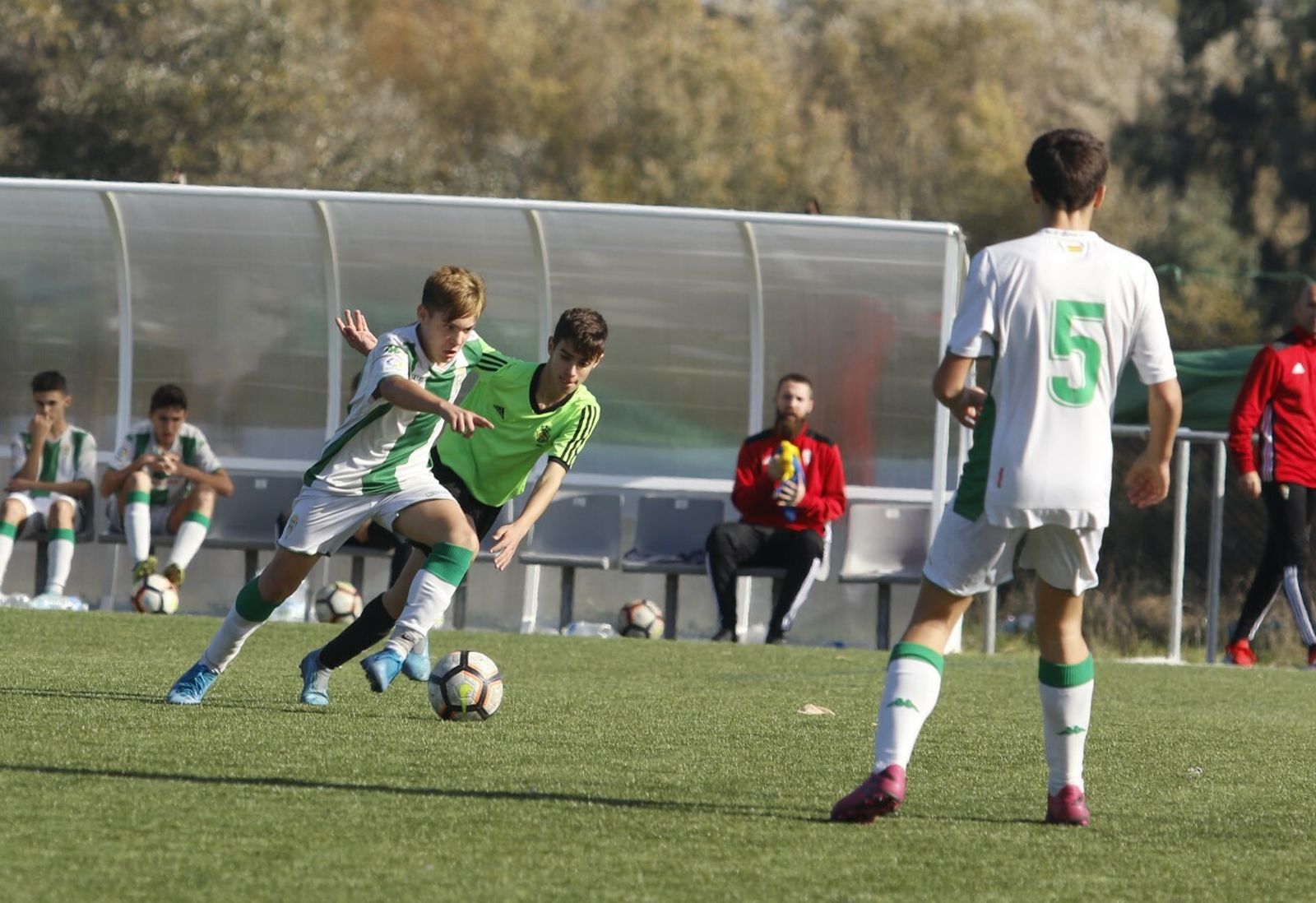 Un jugador del Córdoba escapa de la presión de un jugador del Recreativo de Huelva.