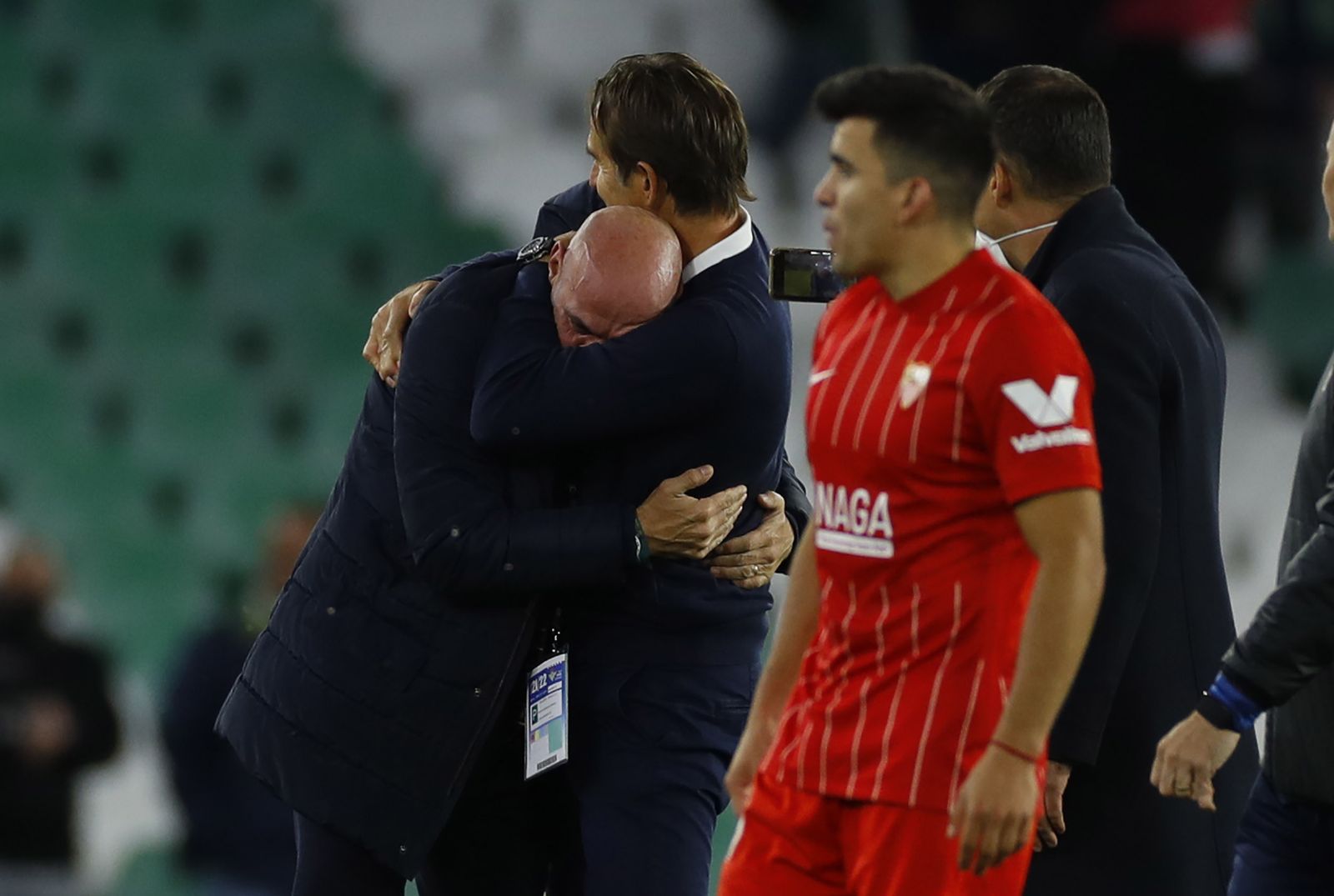 Monchi y Lopetegui se abrazan ante Acuña, a la finalización del derbi.