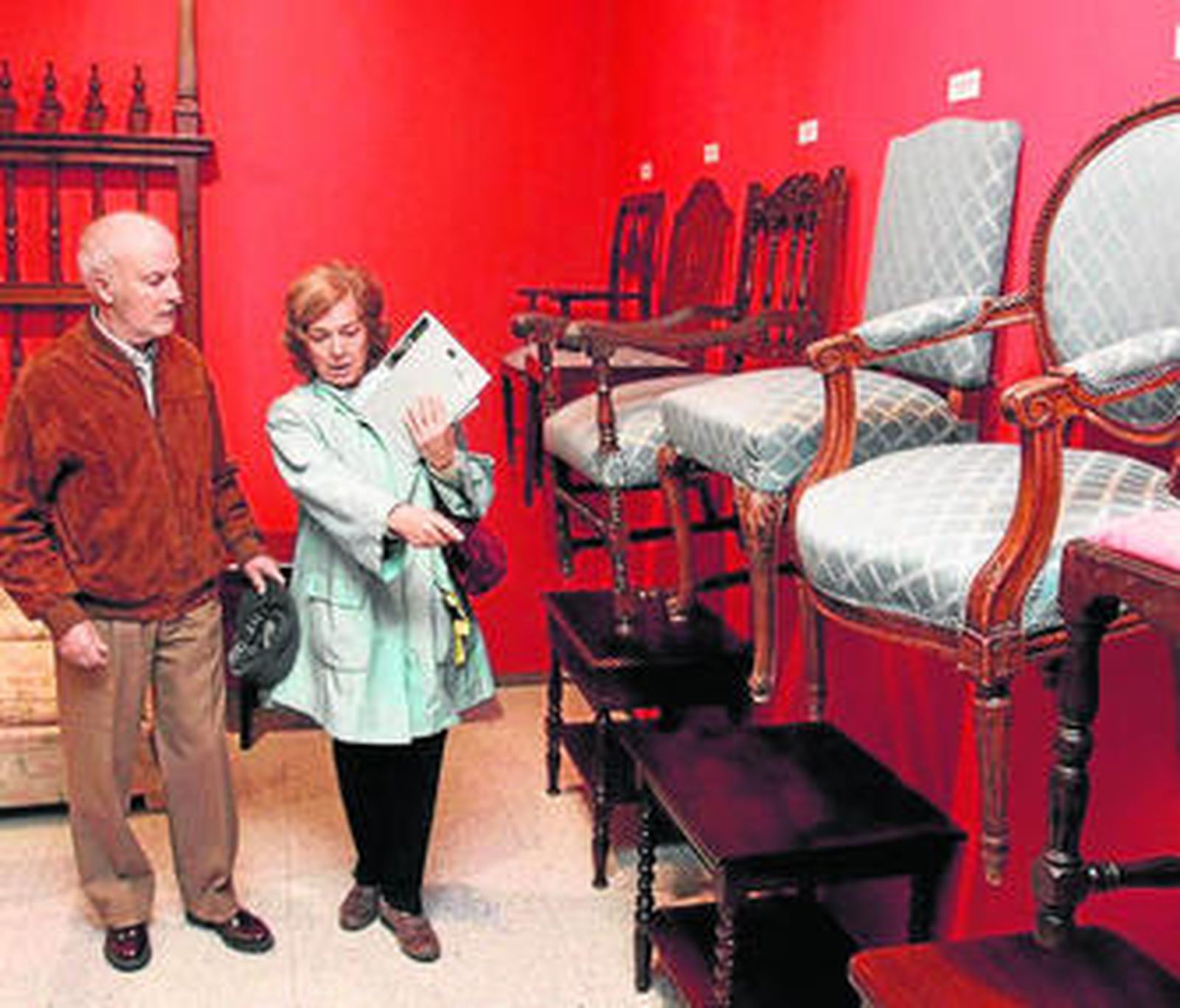 1. Dos clientes buscan algo de su interés entre mesas bajas, sillones, sillas y cabeceros de cama. 2. Una visitante de la muestra observa un tocador que perteneció a una de las habitaciones del hotel. 3. Sofás y lámparas también se pueden adquirir en esta subasta que se expone en Cajasol