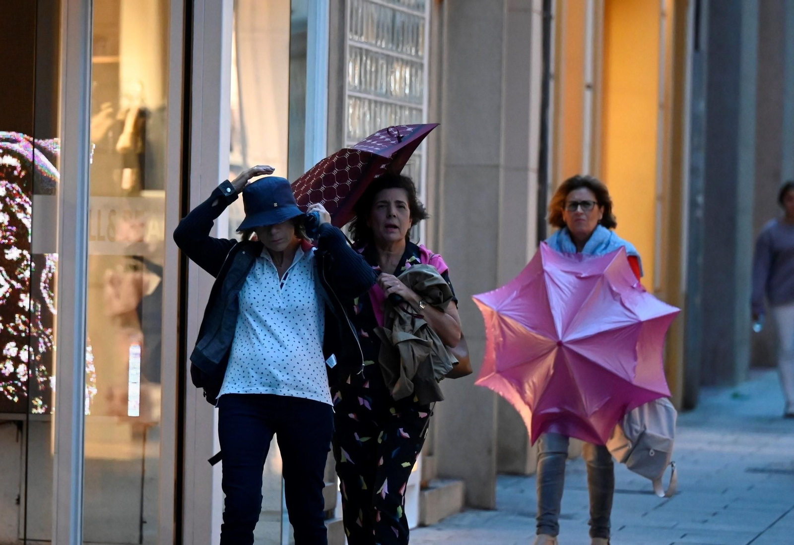 Tres mujeres se protegen de la lluvia en el Cantro de Córdoba.