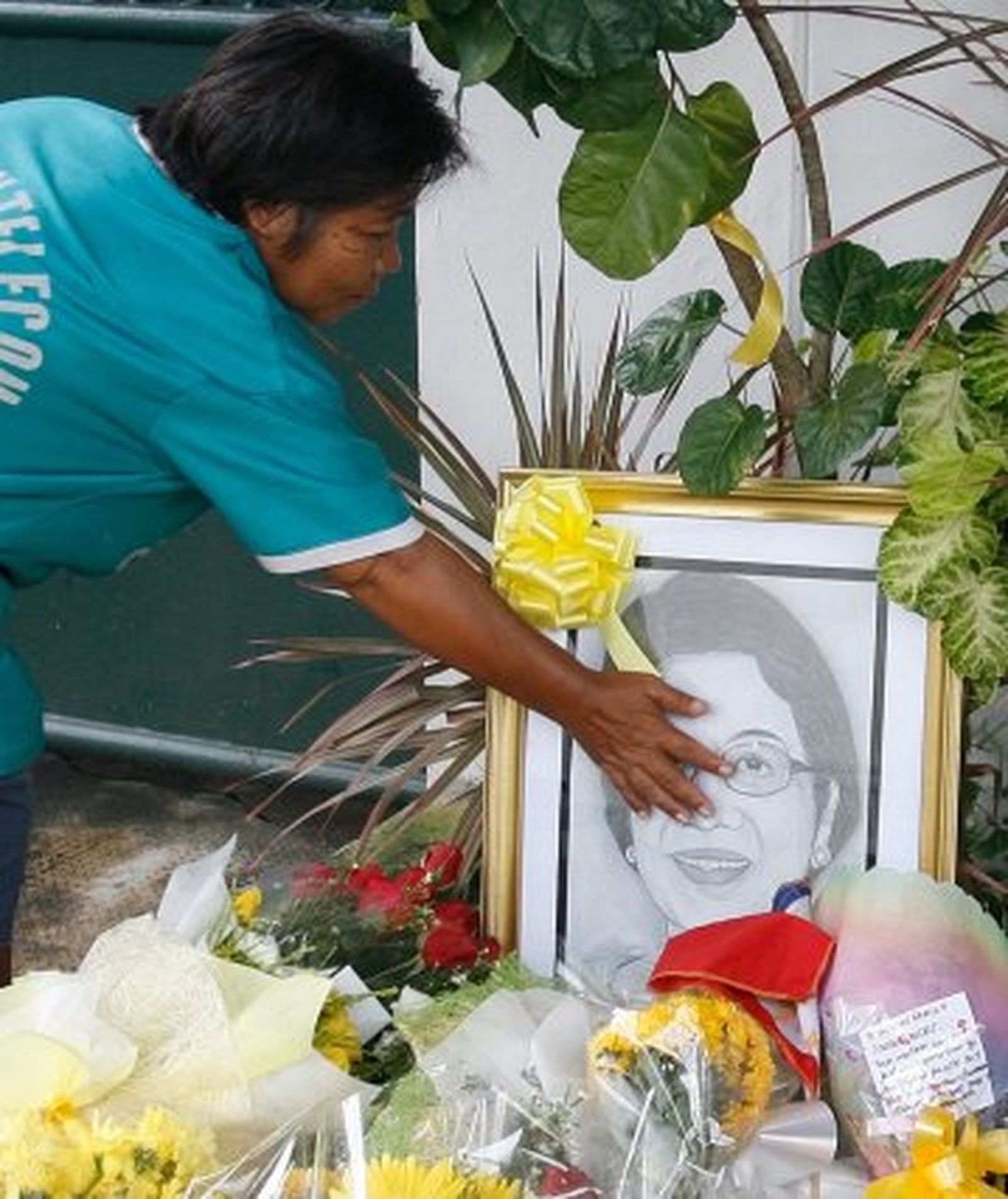 Una mujer deposita flores en un santuario improvisado por la muerte de Corazón Aquino, que ha pasado  a la historia como la primera mujer que presidió Filipinas. / AFP Photo · Reuters